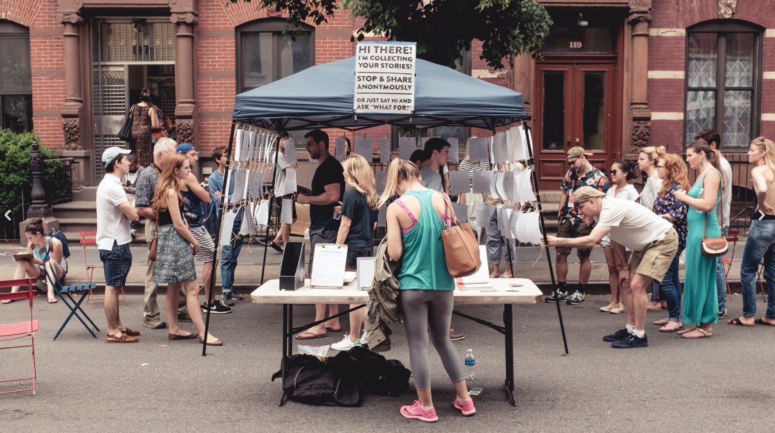 people looking at handwritten notes outdoors